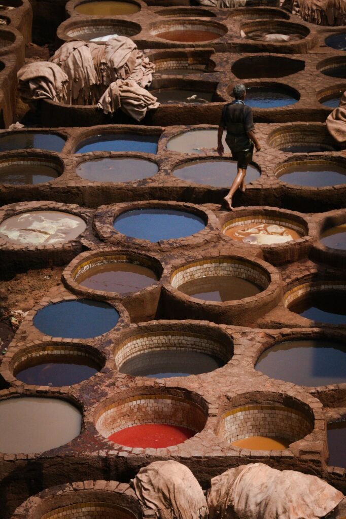 Un homme se promène dans les tanneries traditionnelles de Fès, au Maroc, dotées de cuves de teinture aux couleurs vives.