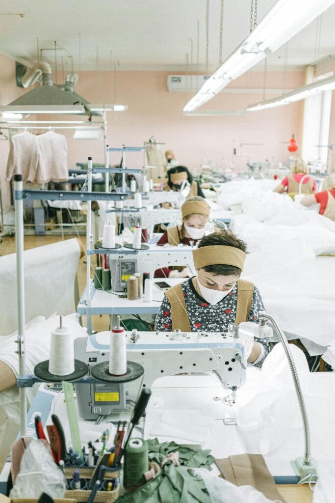 Femmes travaillant avec des machines à coudre dans une usine textile, axées sur la production.